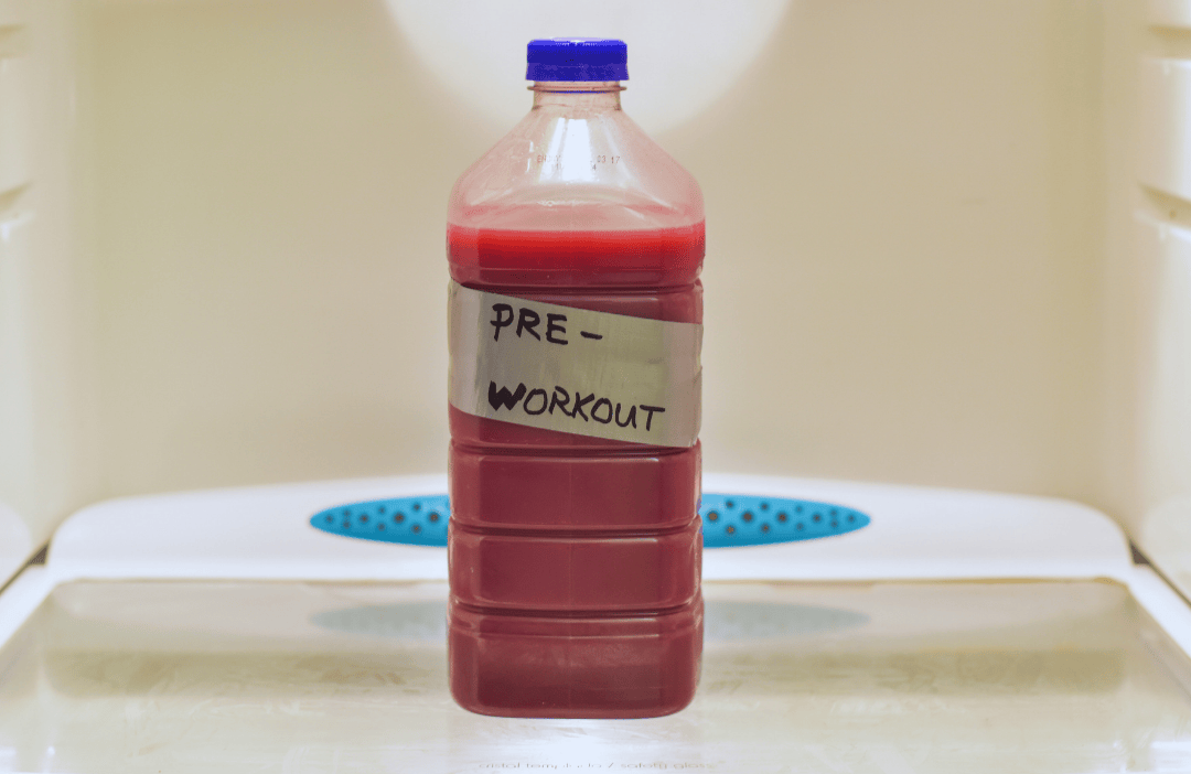 A bottle of homemade pre-workout sitting alone on a refrigerator shelf.